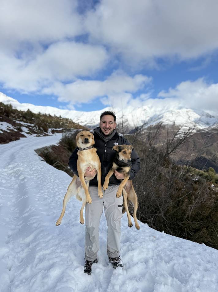 En la nieve con los dos perros en brazos