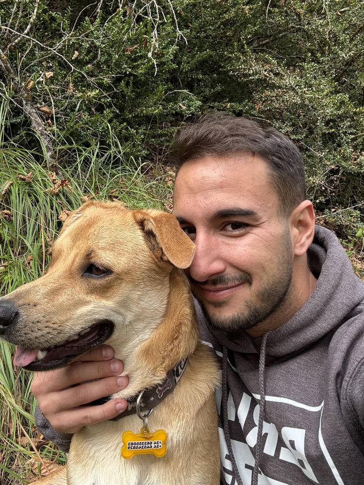Adrián con uno de sus perros en el campo